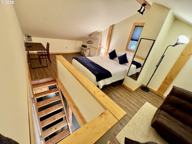 bedroom with vaulted ceiling and light wood-type flooring