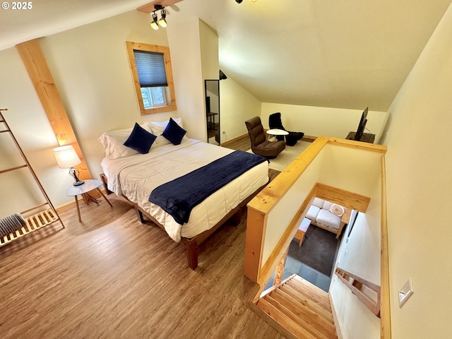 bedroom with vaulted ceiling and wood-type flooring