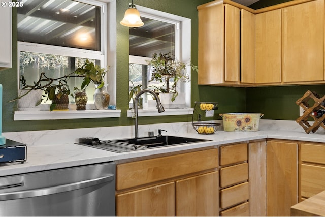 kitchen featuring light stone counters, stainless steel dishwasher, decorative light fixtures, and sink