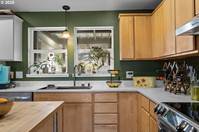 kitchen with pendant lighting, sink, white cabinetry, and appliances with stainless steel finishes