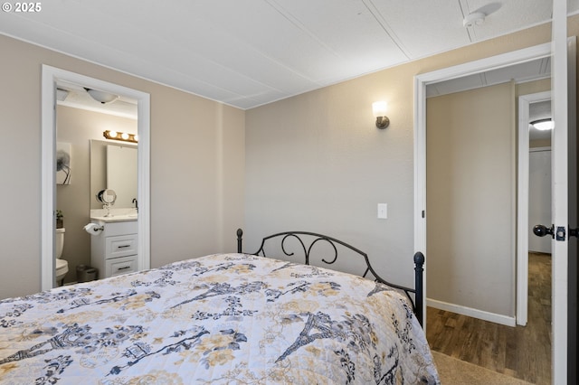 bedroom with hardwood / wood-style flooring and connected bathroom