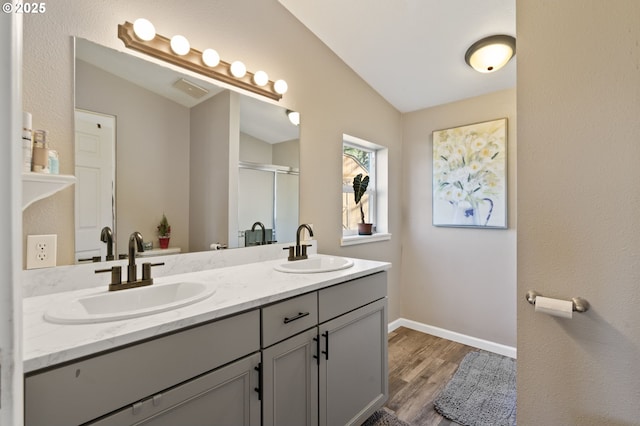 bathroom featuring vanity, an enclosed shower, vaulted ceiling, and hardwood / wood-style floors