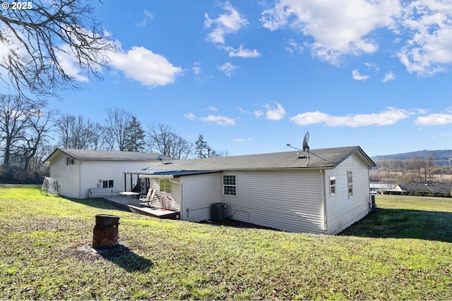 rear view of property featuring a patio, central AC, and a lawn