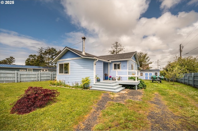 rear view of house with a storage shed, an outbuilding, and a deck