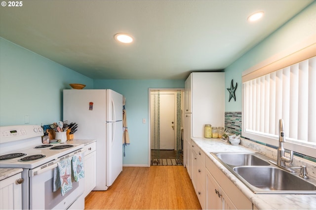 kitchen with white appliances, a sink, light wood-style floors, recessed lighting, and light countertops