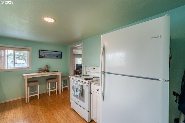 kitchen featuring white appliances, light wood-style floors, white cabinets, light countertops, and recessed lighting