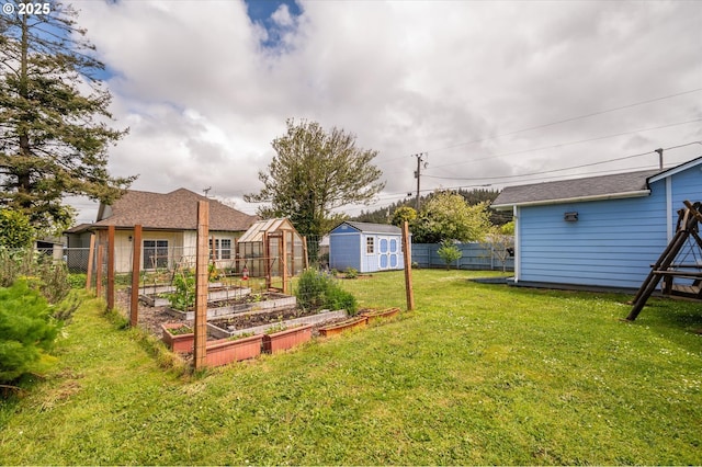view of yard with a garden, an outbuilding, and a storage unit
