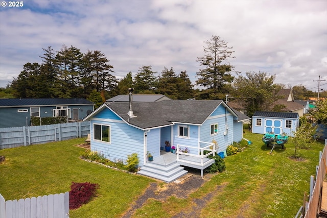 view of front of property with a shingled roof, a storage unit, an outdoor structure, and a wooden deck