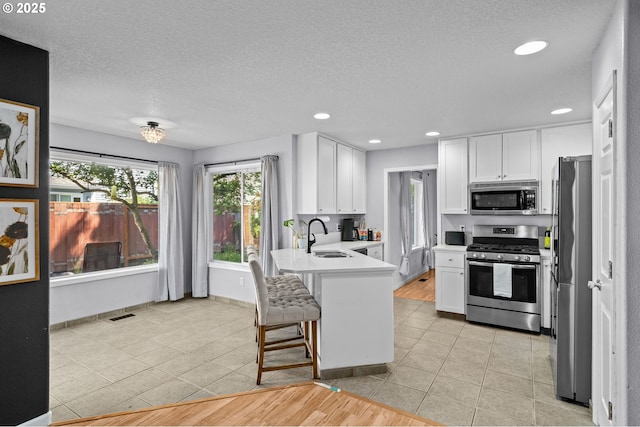 42015 NW Buckshire St, Banks, OR 97106 - kitchen with a peninsula, appliances with stainless steel finishes, white cabinetry, and a sink