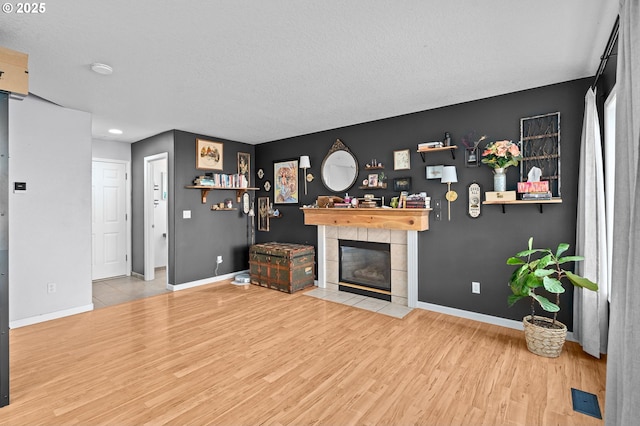 42015 NW Buckshire St, Banks, OR 97106 - living room with baseboards, visible vents, wood finished floors, and a tile fireplace