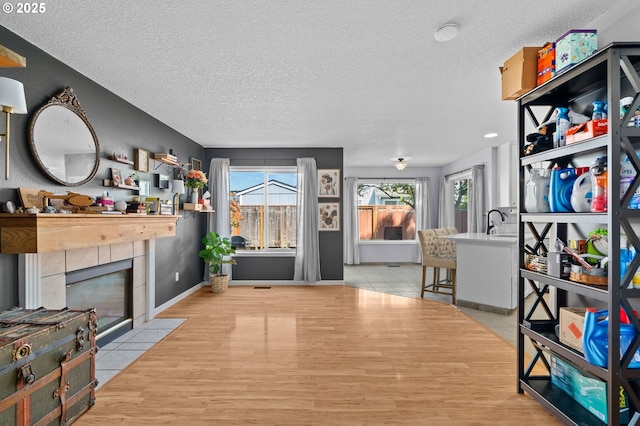 42015 NW Buckshire St, Banks, OR 97106 - interior space featuring baseboards, a textured ceiling, a tiled fireplace, and wood finished floors