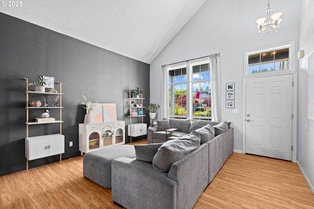 42015 NW Buckshire St, Banks, OR 97106 - living room featuring baseboards, light wood-style flooring, a notable chandelier, and high vaulted ceiling