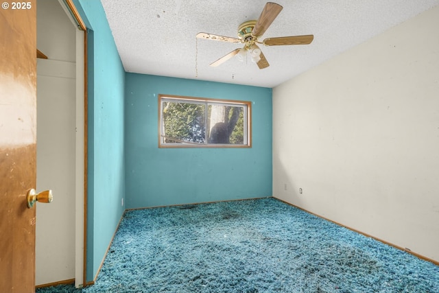 carpeted empty room with ceiling fan and a textured ceiling