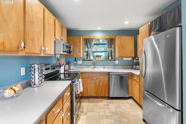 9333 SW 4th Ave, Portland, OR 97219 - kitchen featuring appliances with stainless steel finishes, a sink, light countertops, light stone finish floors, and recessed lighting