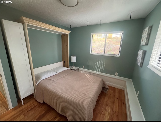 9333 SW 4th Ave, Portland, OR 97219 - bedroom with wood finished floors, baseboards, and a textured ceiling