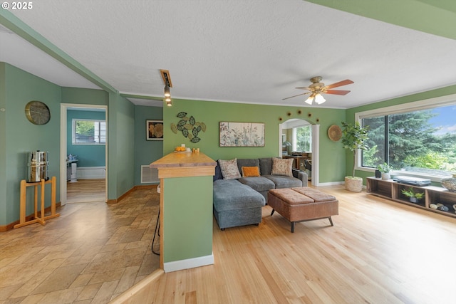 9333 SW 4th Ave, Portland, OR 97219 - living room with plenty of natural light, a ceiling fan, baseboards, arched walkways, and a textured ceiling