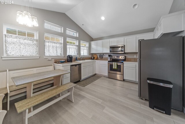 369 B St, Elkton, OR 97436 - kitchen with appliances with stainless steel finishes, white cabinets, high vaulted ceiling, a chandelier, and light countertops