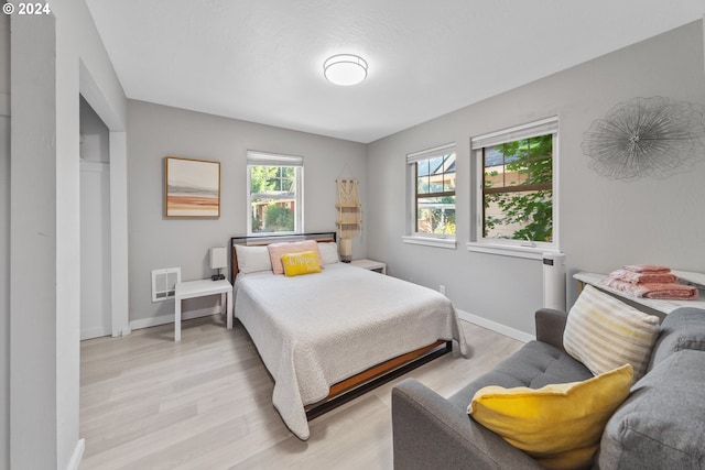 bedroom with light wood-style floors and baseboards