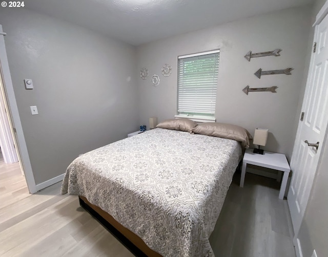 bedroom featuring light wood-type flooring and baseboards