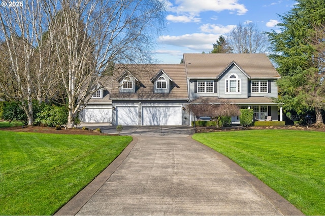 view of front of house featuring a garage, driveway, and a front lawn