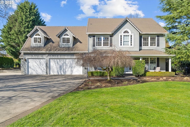 view of front of house with a tile roof, a porch, a garage, driveway, and a front lawn