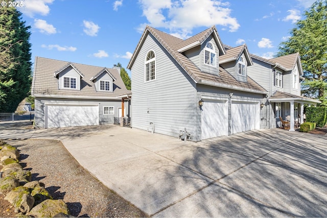 view of property exterior with a garage, concrete driveway, and fence