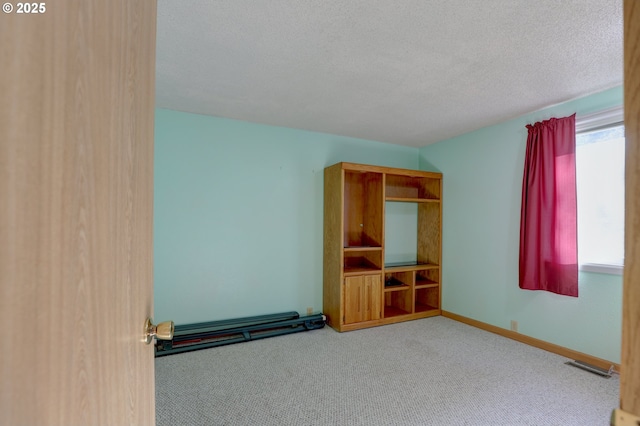 interior space with visible vents, a textured ceiling, and baseboards