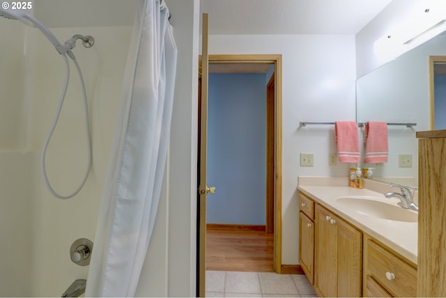 full bathroom featuring shower / tub combo, vanity, baseboards, and tile patterned floors