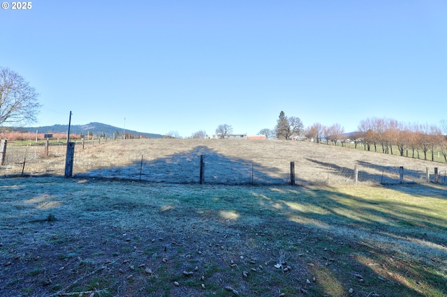 view of yard featuring fence and a rural view