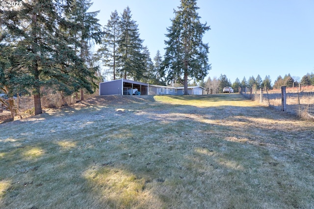 view of yard featuring an outbuilding, a rural view, and an attached carport