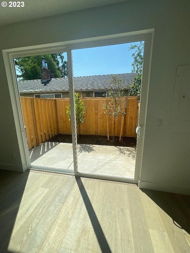 entryway featuring plenty of natural light, electric panel, and light hardwood / wood-style floors