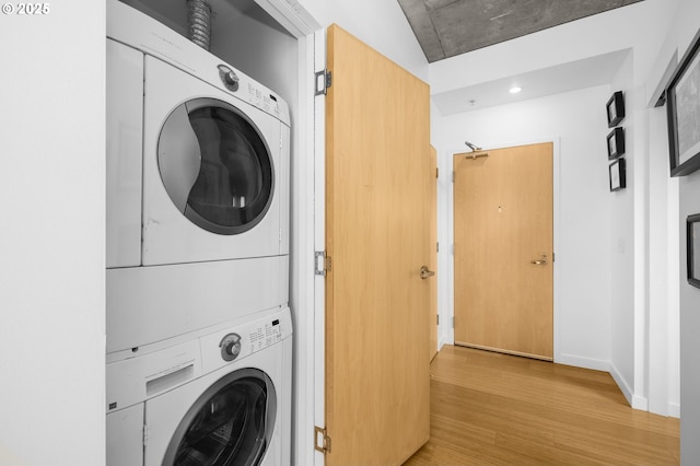 1234 SW 18th Ave Unit 305, Portland, OR 97205 - washroom featuring stacked washing maching and dryer, wood finished floors, laundry area, and baseboards