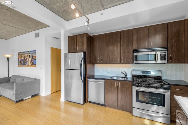 1234 SW 18th Ave Unit 305, Portland, OR 97205 - kitchen with visible vents, a sink, light wood-type flooring, appliances with stainless steel finishes, and dark brown cabinets