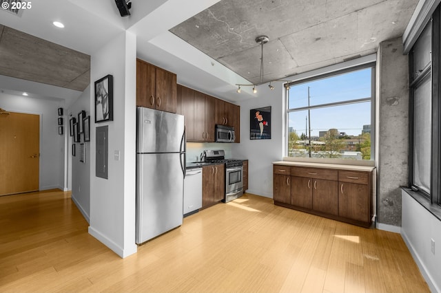 kitchen with light wood-type flooring, appliances with stainless steel finishes, dark brown cabinets, and electric panel