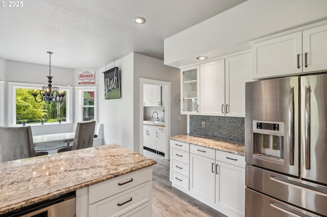 12875 Peggys Pl, Hubbard, OR 97032 - kitchen featuring stainless steel fridge with ice dispenser, glass insert cabinets, white cabinets, tasteful backsplash, and a sink