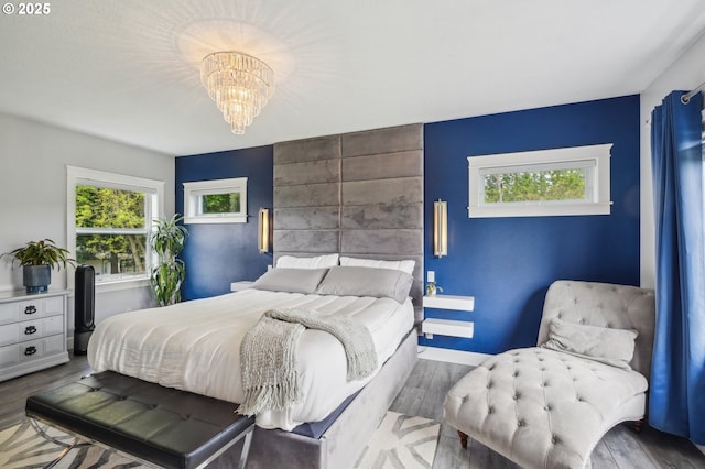 12875 Peggys Pl, Hubbard, OR 97032 - bedroom featuring baseboards, an accent wall, wood finished floors, and a notable chandelier