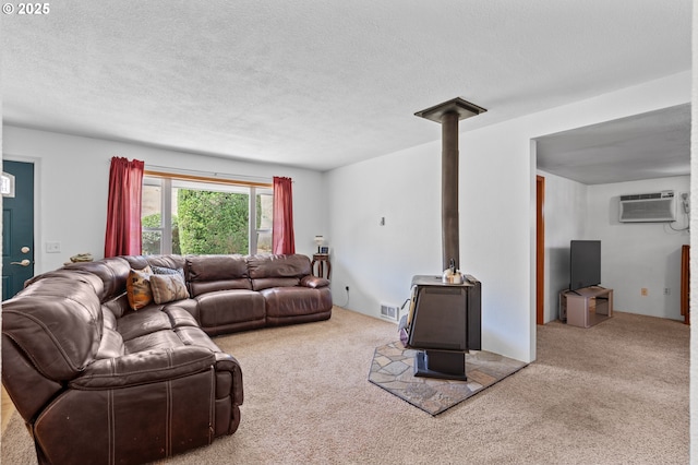 814 SW 44th St, Pendleton, OR 97801 - living area featuring a wood stove, a wall mounted air conditioner, carpet floors, and a textured ceiling