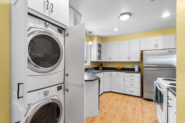 814 SW 44th St, Pendleton, OR 97801 - washroom featuring stacked washer / drying machine, light wood-type flooring, and recessed lighting
