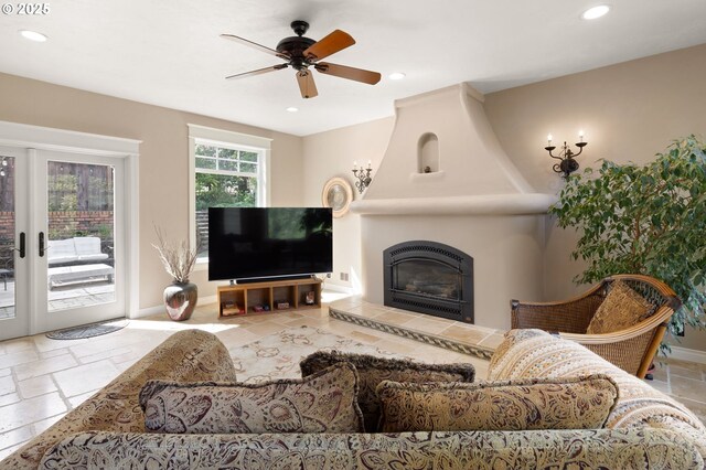living room with a tiled fireplace, baseboards, a ceiling fan, and recessed lighting