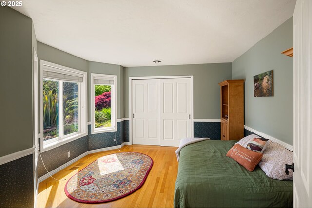 bedroom featuring baseboards, a closet, and wood finished floors