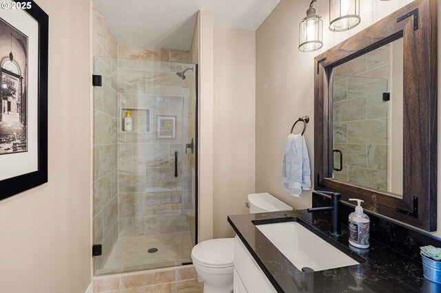 full bath with vanity, a shower stall, and toilet