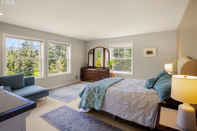 bedroom featuring baseboards, multiple windows, light carpet, and recessed lighting