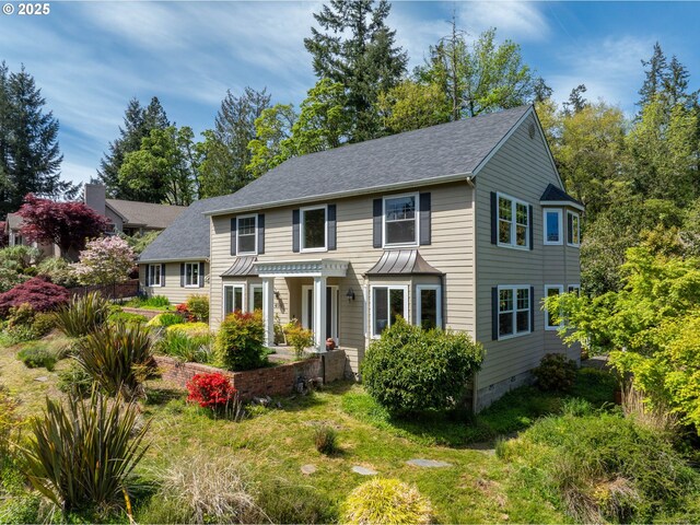 colonial inspired home with roof with shingles, crawl space, and a standing seam roof