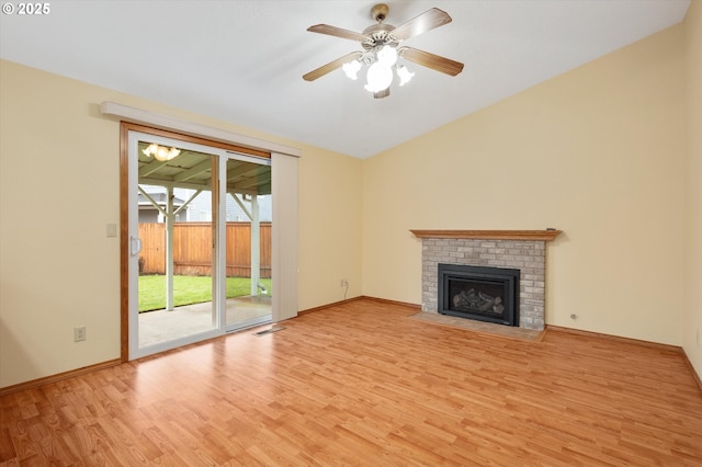 unfurnished living room featuring ceiling fan, lofted ceiling, a brick fireplace, and light hardwood / wood-style flooring