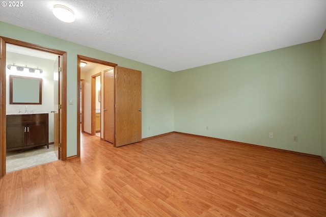 empty room featuring a textured ceiling and light wood-type flooring