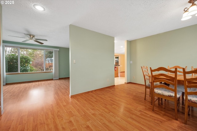 dining space featuring ceiling fan, light hardwood / wood-style floors, and a textured ceiling