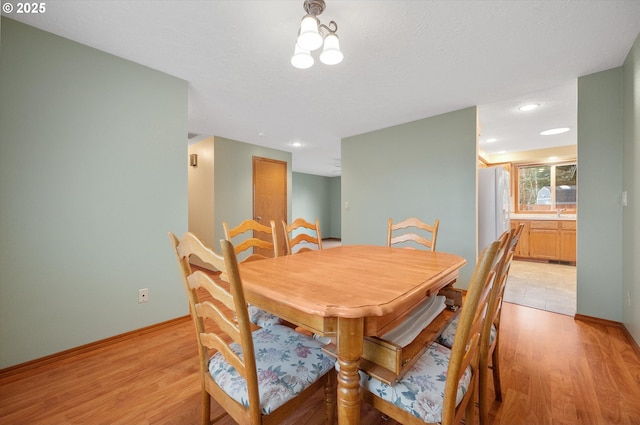 dining space featuring a textured ceiling and light hardwood / wood-style floors