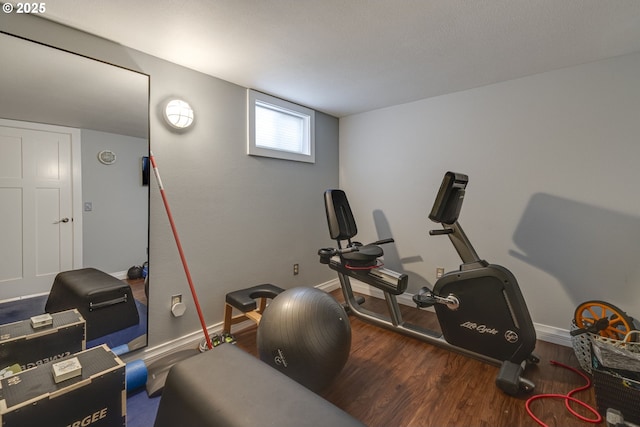 workout room featuring baseboards and wood finished floors