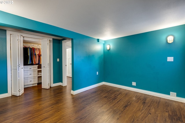 unfurnished bedroom featuring baseboards and wood finished floors
