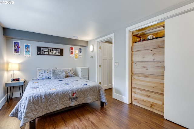 bedroom with baseboards and wood finished floors
